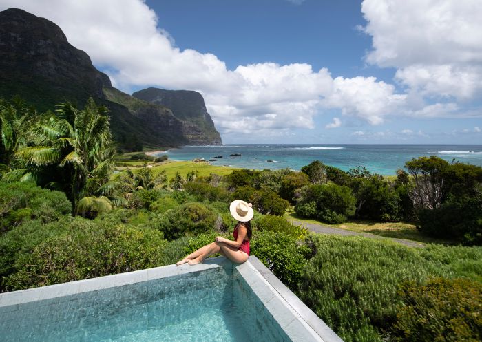 Woman relaxing by the pool at Capella Lodge, Lord Howe Island 
