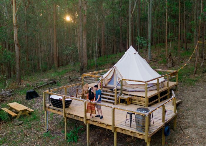 Couple on the deck of their glamping tent at Into The Wild Escapes, Kookaburra Ridge