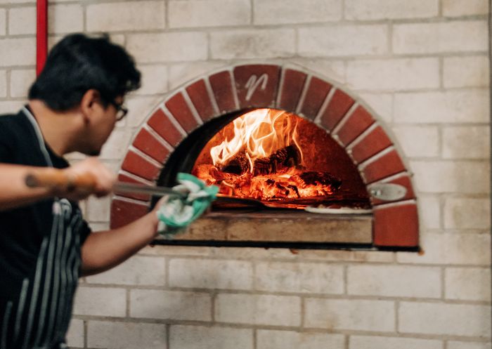 Pizza maker in front of woodfire at Parry Street Garage, Newcastle