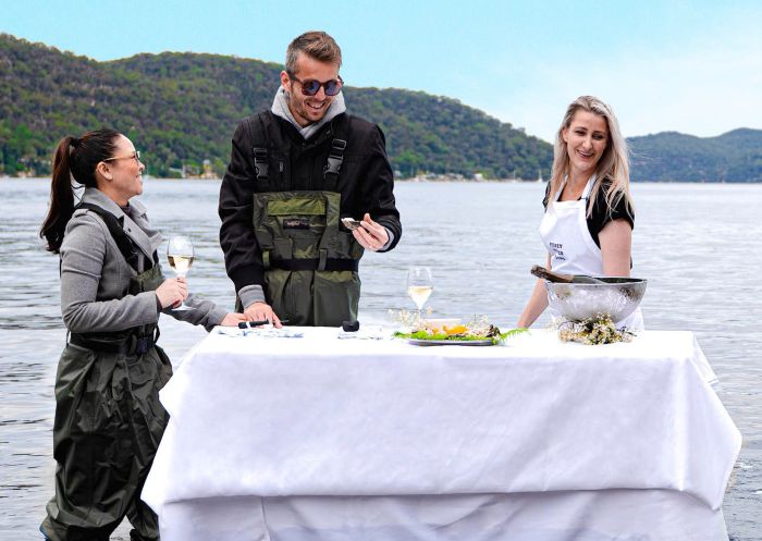 Couple enjoy in water dining at Sydney Oyster Farm Tours, Mooney Mooney