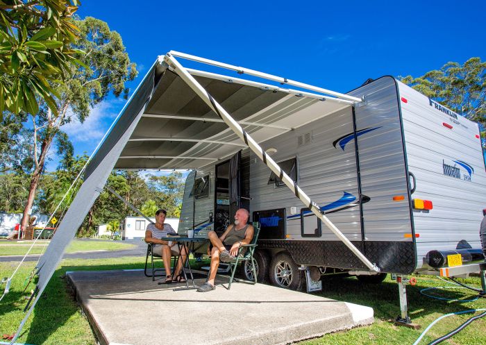 Couple sitting outside caravan at Reflections Holiday Parks Coffs Harbour, Coffs Harbour