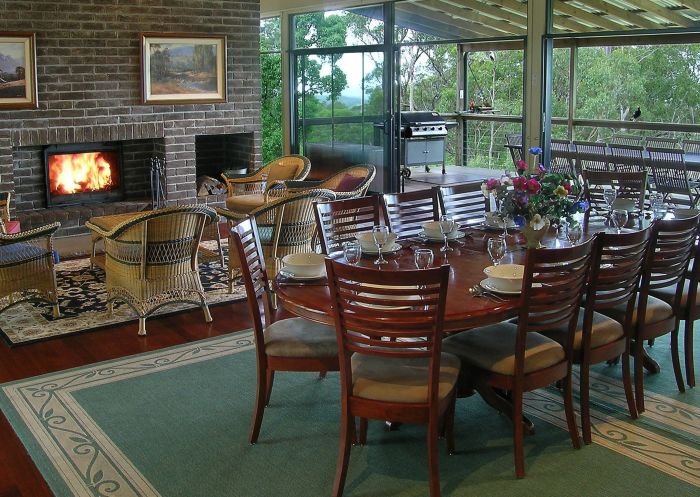 Dining area with open fireplace at Banjos Bushland Retreat, Hunter Valley
