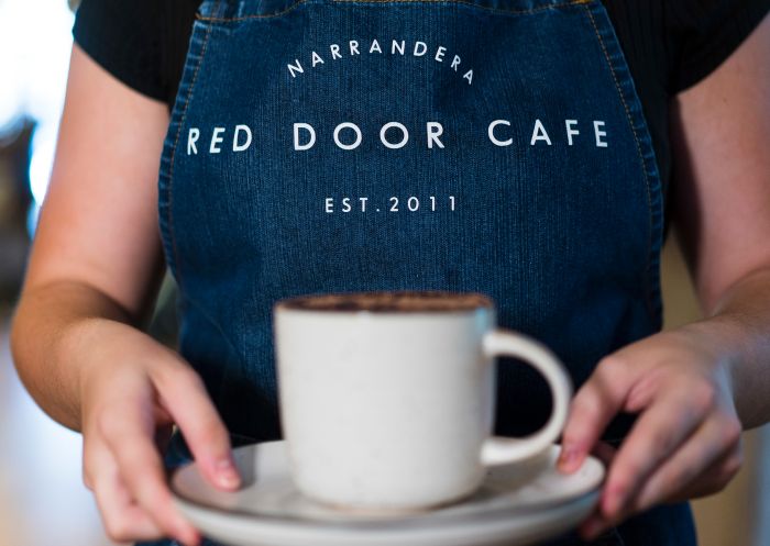 Waitress serving a cup of coffee at The Red Door Cafe and Juadine Interiors, Narrandera