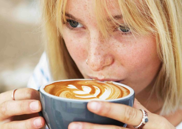 Woman enjoying coffee at Salty Crew Kiosk, Port Macquarie