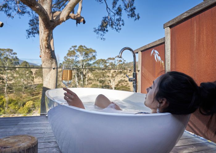 Woman enjoying outdoor bath at Currajong Retreat, Burragate