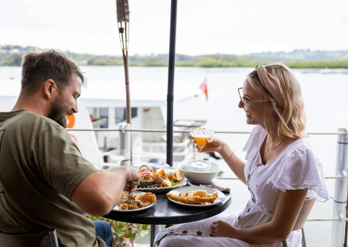 Smiling couple enjoy a seafood meal, The Oyster Shed, Tweed River - Credit: Ryan Fowler