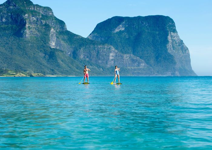 Couple stand-up paddleboarding, Lagoon Beach, Lord Howe Island