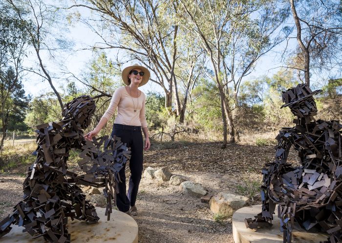 Woman enjoying the sculptures on a visit, Peak Hill Open Cut Gold Mine in Peak Hill, Parkes Area
