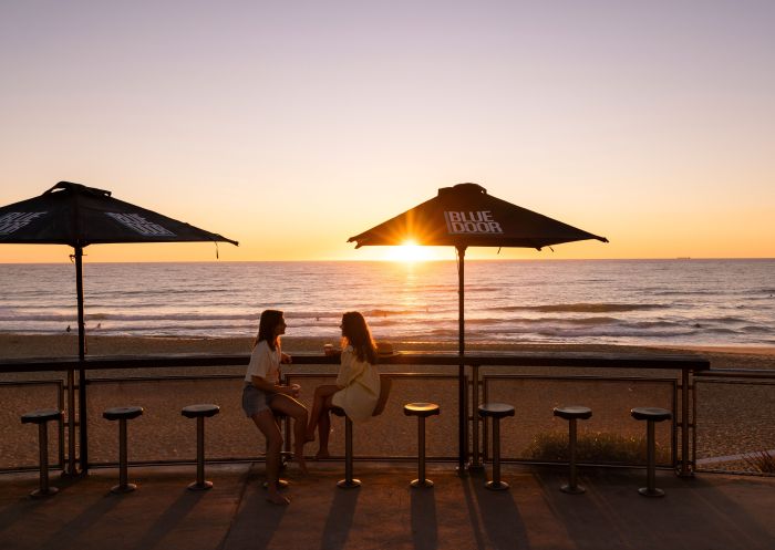 朋友们在纽卡素梅雷韦瑟海滩享受日落饮品