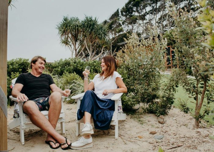 Two people sit in deck chairs holding glasses of wine, Reflections Byron Bay - Holiday Park, Byron Bay - Credit: Reflections Holiday Parks | Jess Kearney 