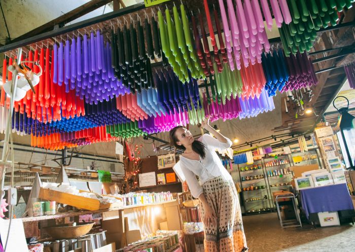Woman exploring colourful candles on ceiling, Nimbin Candle Factory, Nimbin - Credit: Lismore City Council