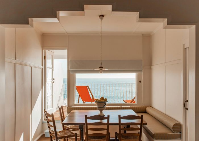 View of indoors to sea view with deckchair and kitchen table, Il Delfino, Yamba - Credit: Anna Pihan | Il Delfino