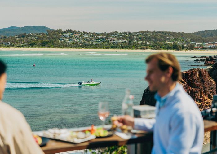 Paar schaut von einem Boot auf dem Wasser mit Blick auf Essen und Meer, Aquarium and Wharf Restaurant, Merimbula