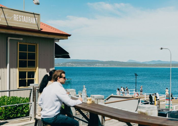 Couple enjoying a meal and ocean views, Aquarium and Wharf Restaurant, Merimbula