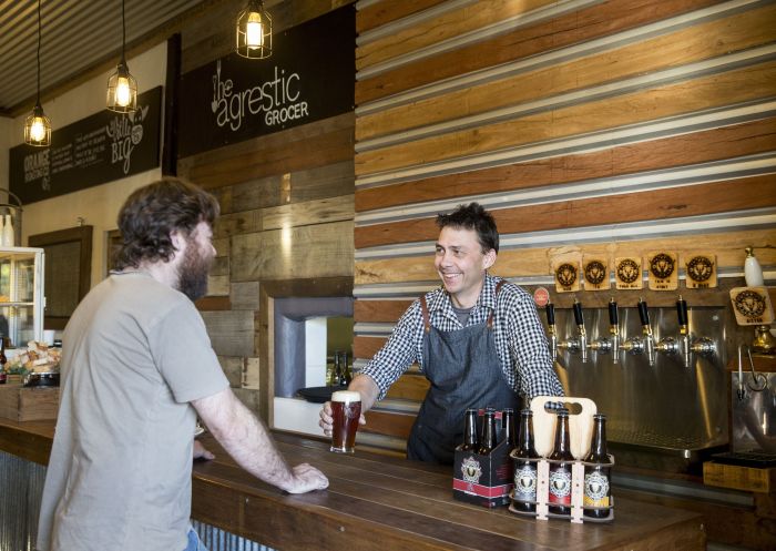Head Brewer Jon Shiner serving customer, Badlands Brewery, Orange