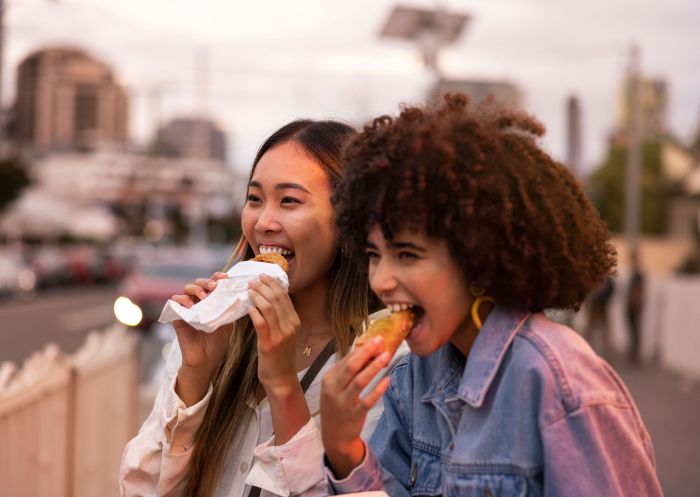 Friends enjoying takeaway food and drink, Little India, Harris Park