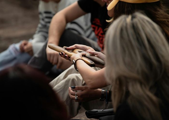 Close up of people holding clapsticks, Natcha Cultural Tours, Mascot - Credit: Natcha Cultural Tours