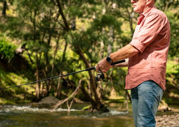 A man trout fishing in a mountain stream as part of Simmo's Off Road Tours, Bathurst