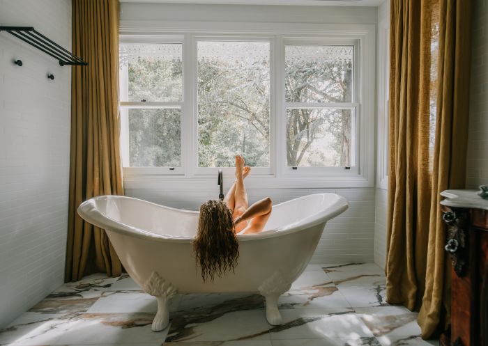 Lady in a bathtub facing a large window in the Littlebourne Guest House, Kelso - Credit: Littlebourne Guest House