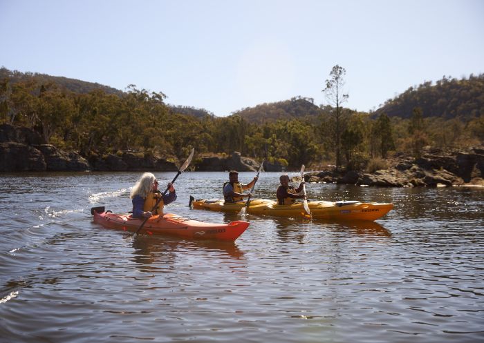 A group of three enjoying a kayaking adventure along a river with Southern Cross Kayaking, Wollemi National Park