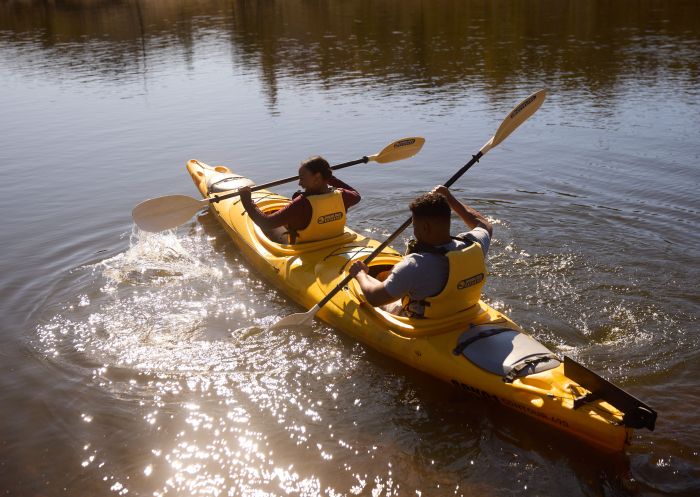 Couple enjoying a kayaking adventure along a river in Wollemi National Park