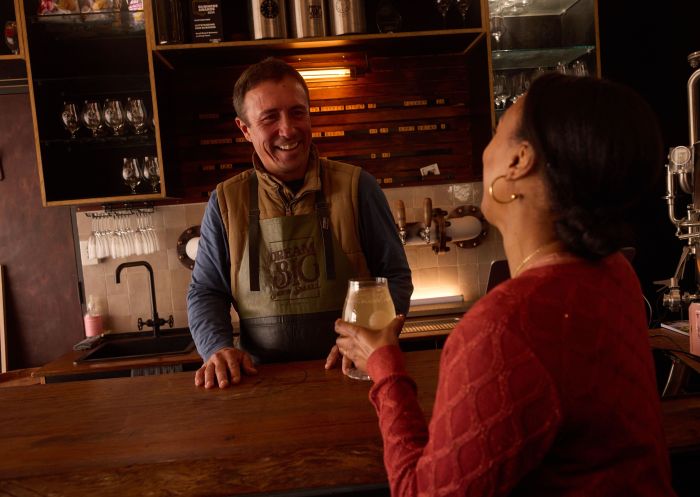 Woman enjoying a drink and chat with resident Brewer at Small Batch Brew, Mudgee