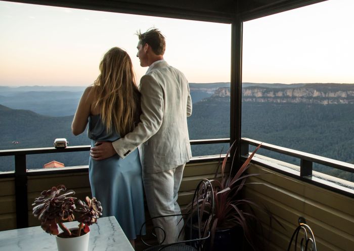 Couple enjoying a drink and views of the sun set from Echoes Boutique Hotel and Restaurant, Katoomba