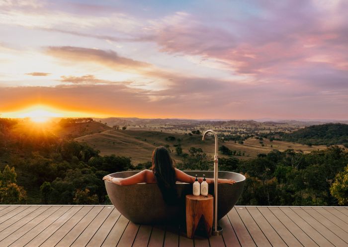 Woman enjoying the sunset in an outdoor bath at Sierra Escape Luxury Glamping, Mudgee - Credit: Sierra Escape