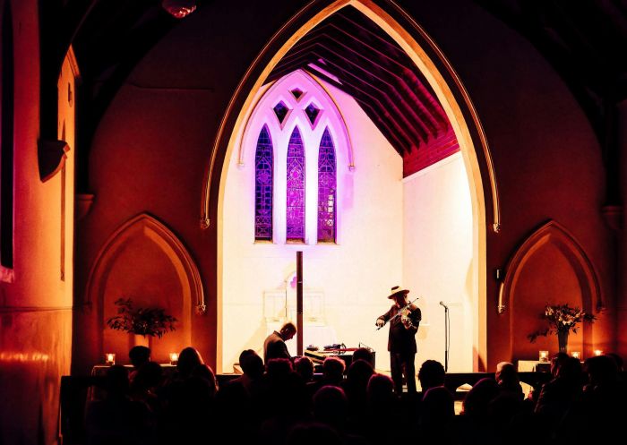 A brightly illuminated church sanctuary with the silhouettes of a pianist, violinist and audience - Credit: Carolyn Hide