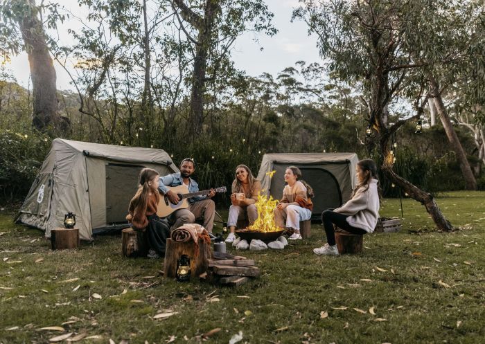 A family sitting around a campfire at BIG4 South Durras Holiday Park, South Durras