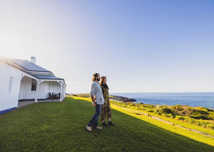 Couple enjoys a walk around the Montague Island Lighthouse on the Montague Island Discovery Tours experience