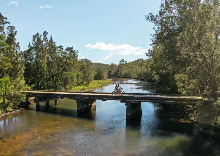 Cycling on a bridge over a shallow river in Tilba - Credit: Eurobodalla Coast Tourism