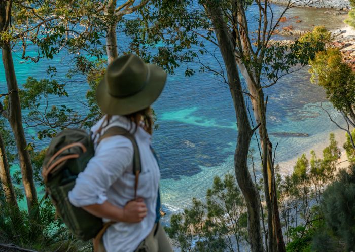 A hiker staring down to the turquoise waters below from a clifftop bush walk on the Munjip Trail, Batemans Bay - Credit: Eurobodalla Coast Tourism