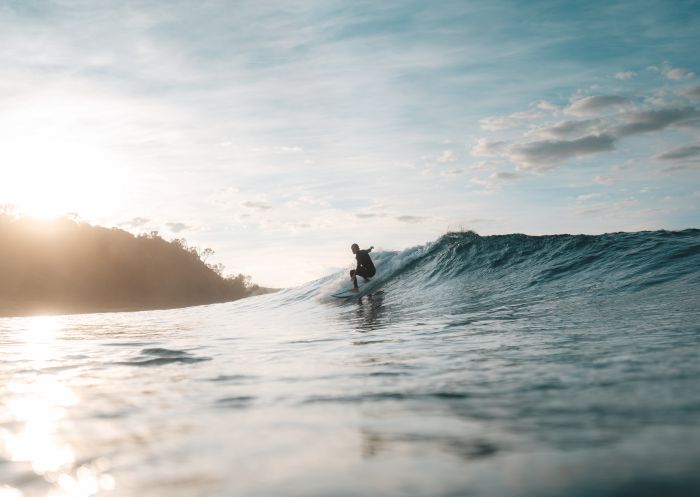 Surfer catching wave, Broulee Beach, Broulee - Credit: Eurobodalla Coast Tourism