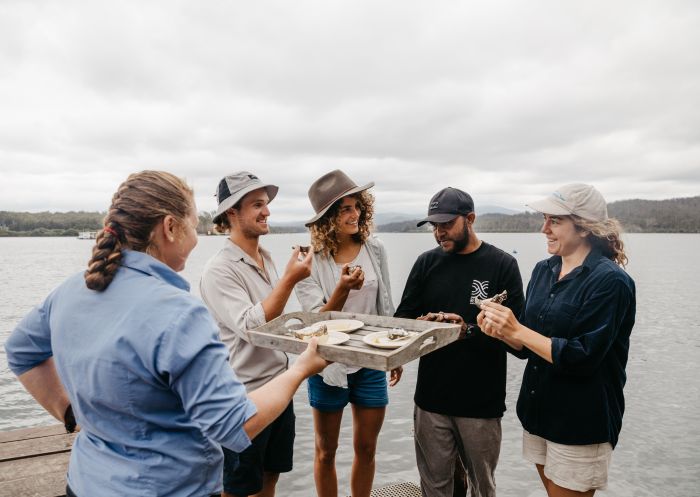 Five people eating fresh oysters at wharf, Oyster tasting, Batemans Bay - Credit: Eurobodalla Coast Tourism