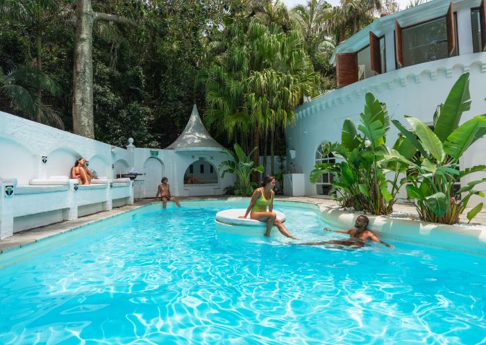 Couples enjoying a dip and lounging by the pool, Raes On Wategos, Byron Bay
