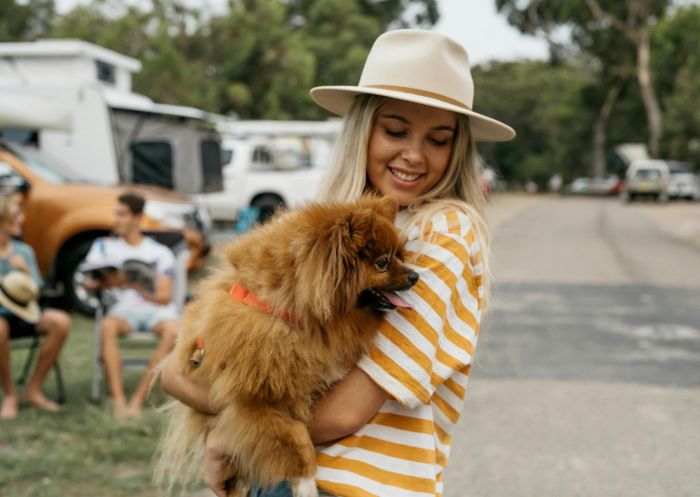 Woman with dog in arms, Reflections Bermagui, Bermagui - Credit: Dom Cherry Creative | Reflections Holiday Parks