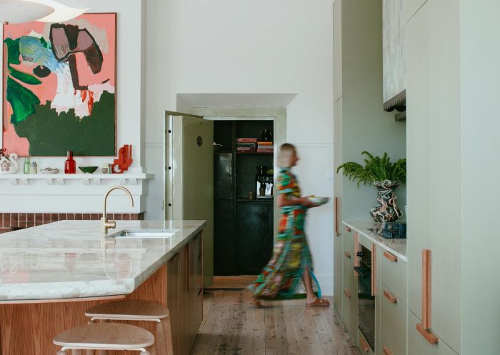 Lady walking past a stylish modern kitchen at Sona, Molong - Credit: Jumbled