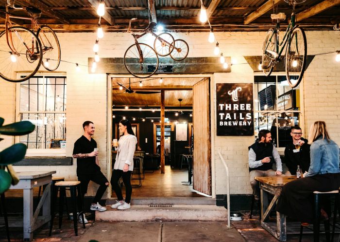 The front entrance of Three Tails Brewery, bikes hanging from the ceiling, and people conversing in Mudgee - Credit: Amber Creative | Three Tails Brewery