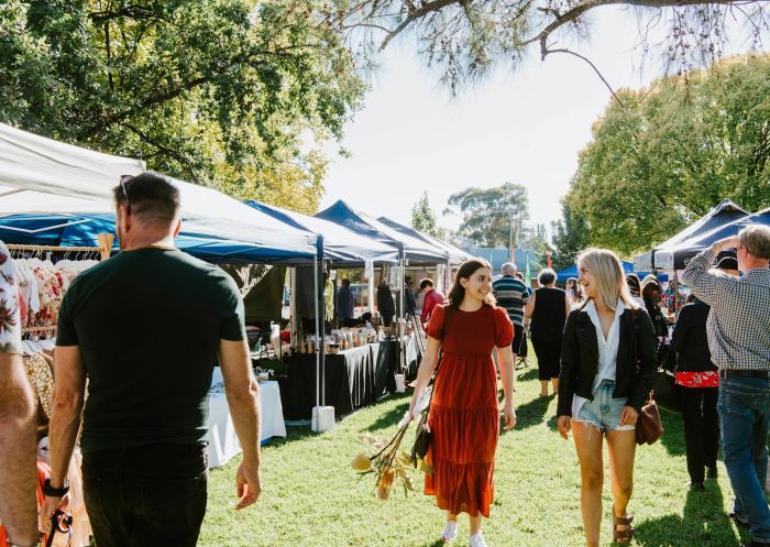 Two ladies walking through the Farmers' Market, flowers in hand in Mudgee - Credit: Amber Creative | Mudgee Fine Foods Inc.