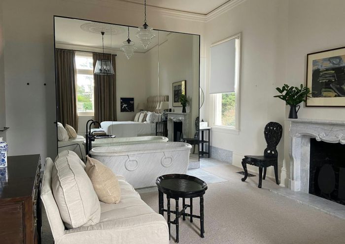 Stylish suite with marble bath in front of a large wall mirror at Moss Manor, Moss Vale - Credit: Moss Manor