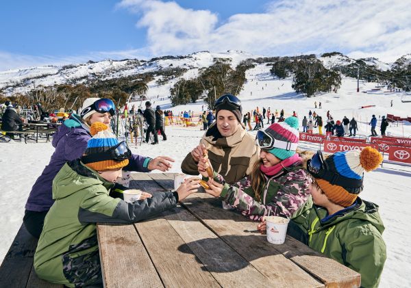 A family warming up with hot chocolates at Thredbo ski resort in the Snowy Mountains