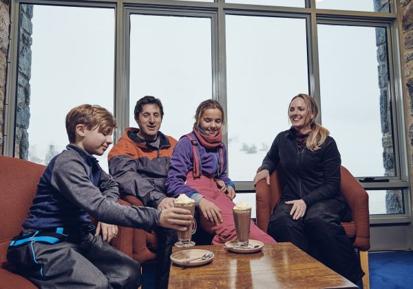 Family enjoying hot chocolate at Snow Gums Restaurant, Perisher, Snowy Mountains