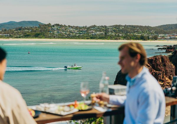 Couple looking over boat on water with food and oceans views, Aquarium and Wharf Restaurant, Merimbula