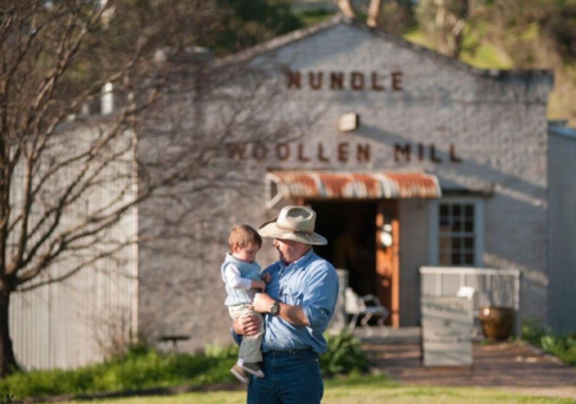 A father holding his child outside Nundle Woollen Mill, Nundle