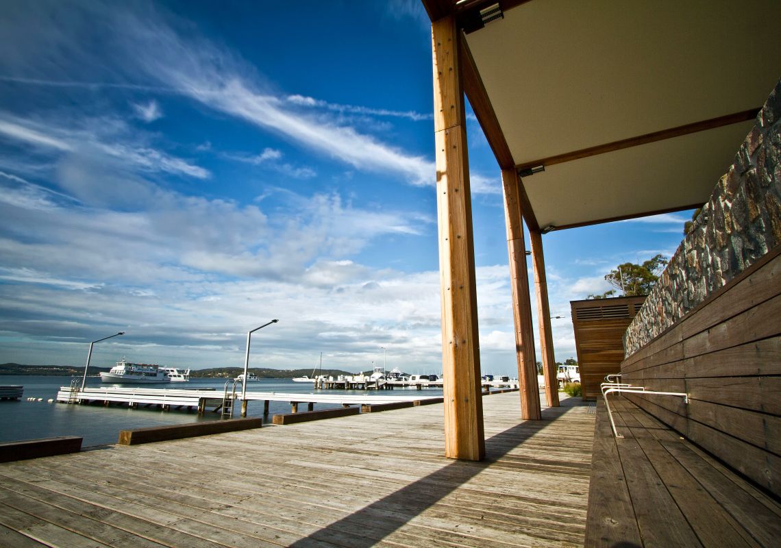 The wooden Toronto public wharf and a tour boat on Lake Macquarie
