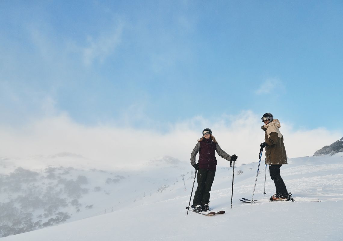 Couple enjoying a day of skiing at Charlotte Pass Ski Resort in the Snowy Mountains