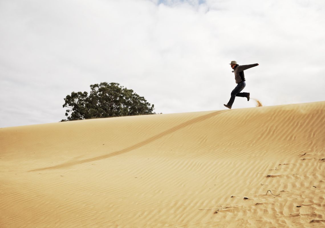 A man runs down the side of a dune at Perry Sandhills, Wentworth