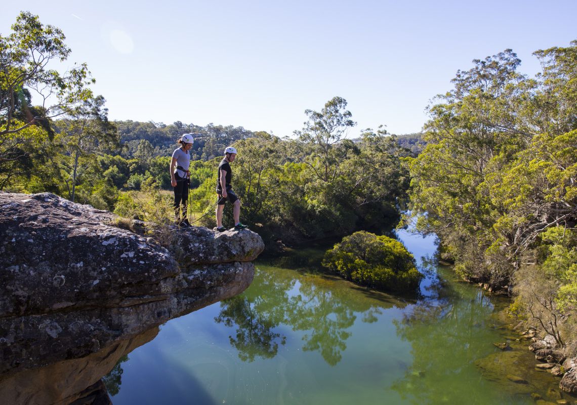 Couple ready to abseil off a clifftop in the Shoalhaven region near Nowra 