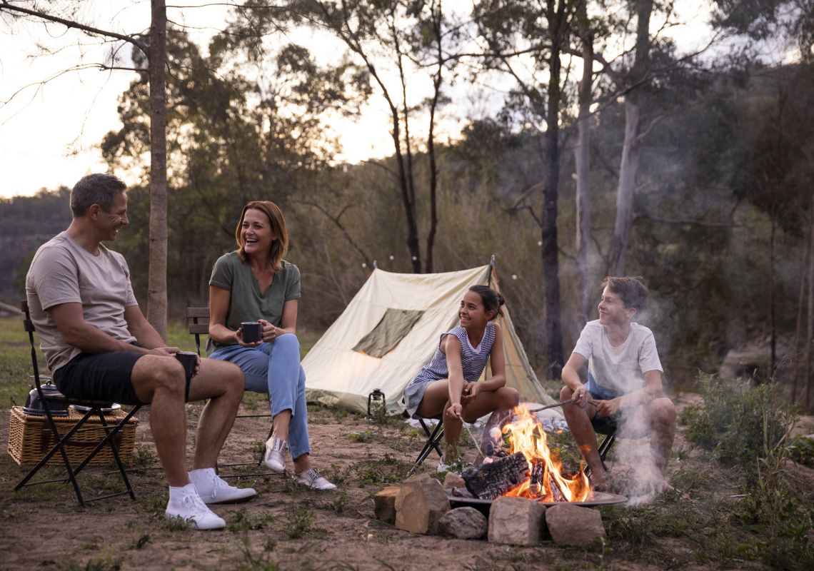 Family enjoying a campfire by their tent on the Hawkesbury River in Lower MacDonald